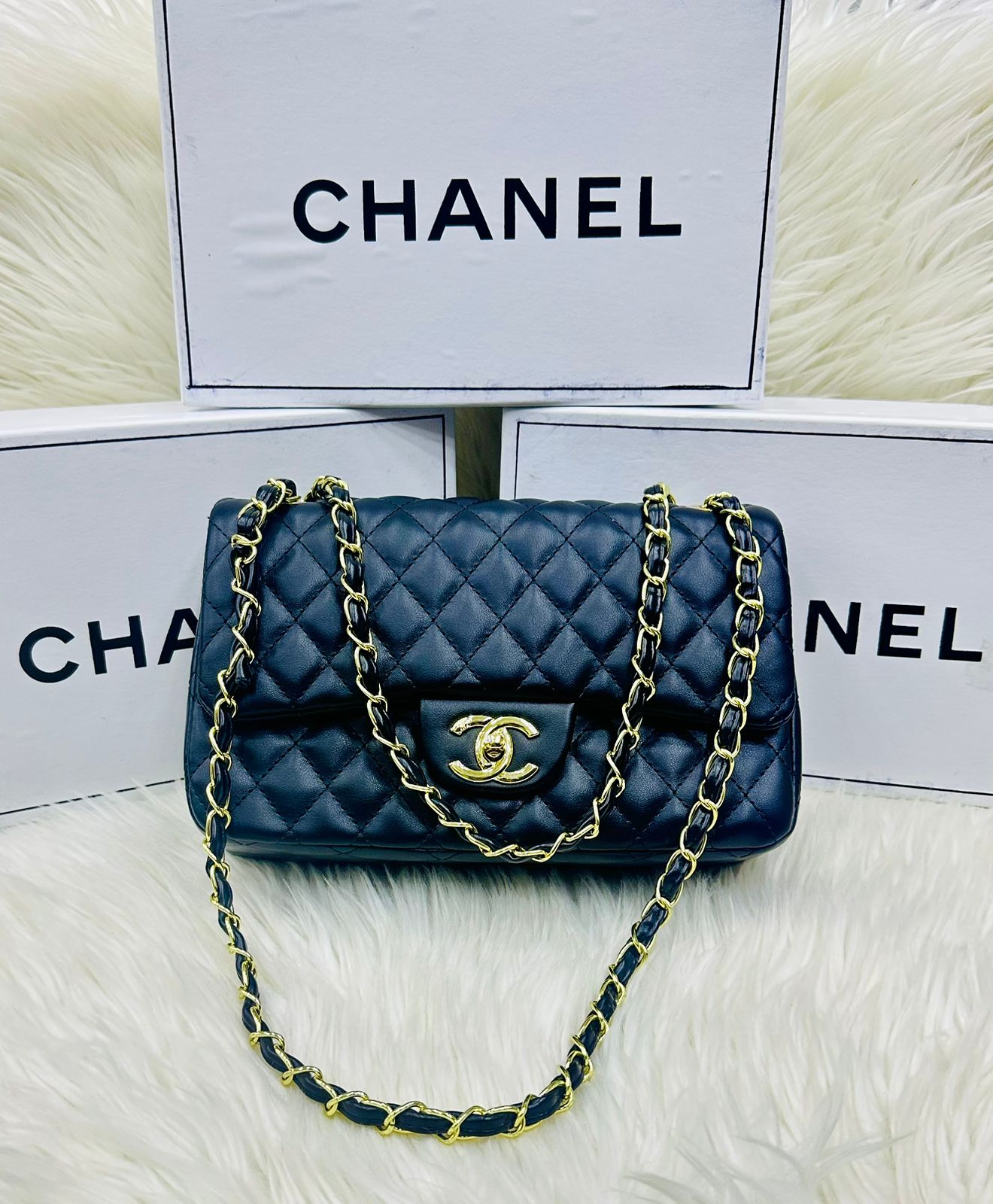 Blue Cha nel handbag with gold chain on a white background