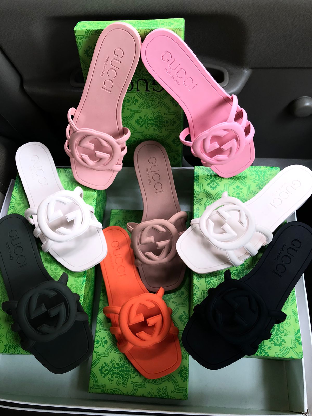 Set of colorful sandals with floral designs on a green box.