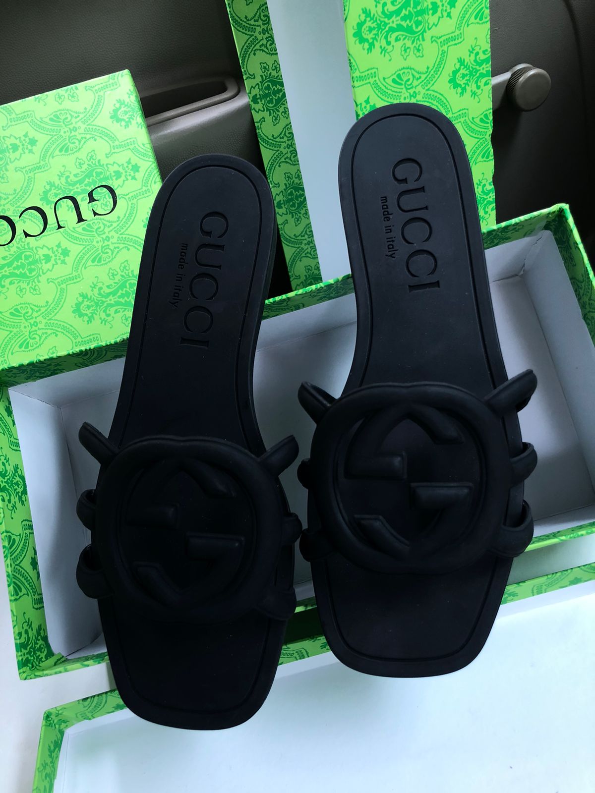 Black Guc ci sandals with floral designs on a green box