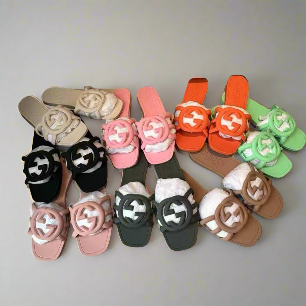 Colorful sandals with decorative straps arranged on a beige surface.