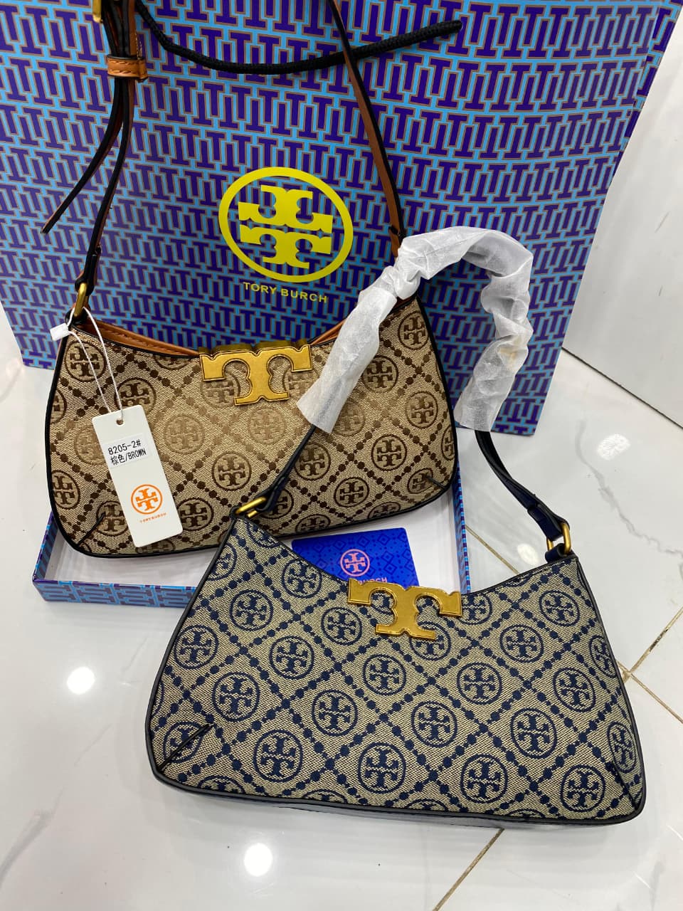 Two handbags with a visible brand logo on a white surface