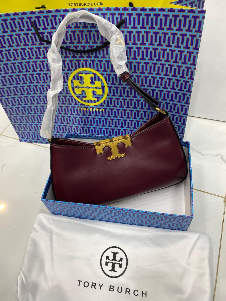 To ry Bur ch handbag in a branded box with a matching tote bag in the background.
