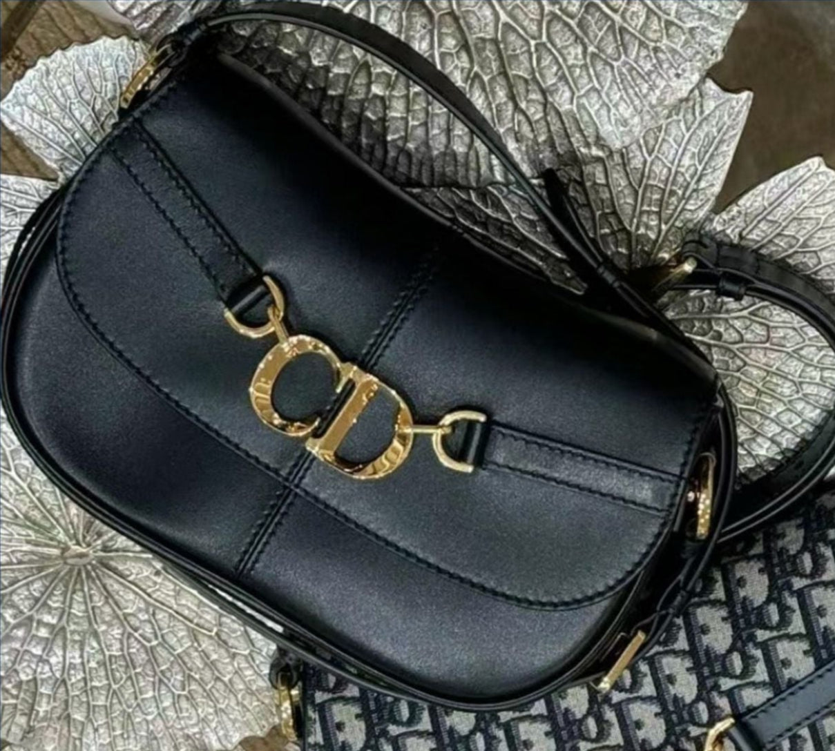 Black handbag with gold hardware on a textured surface