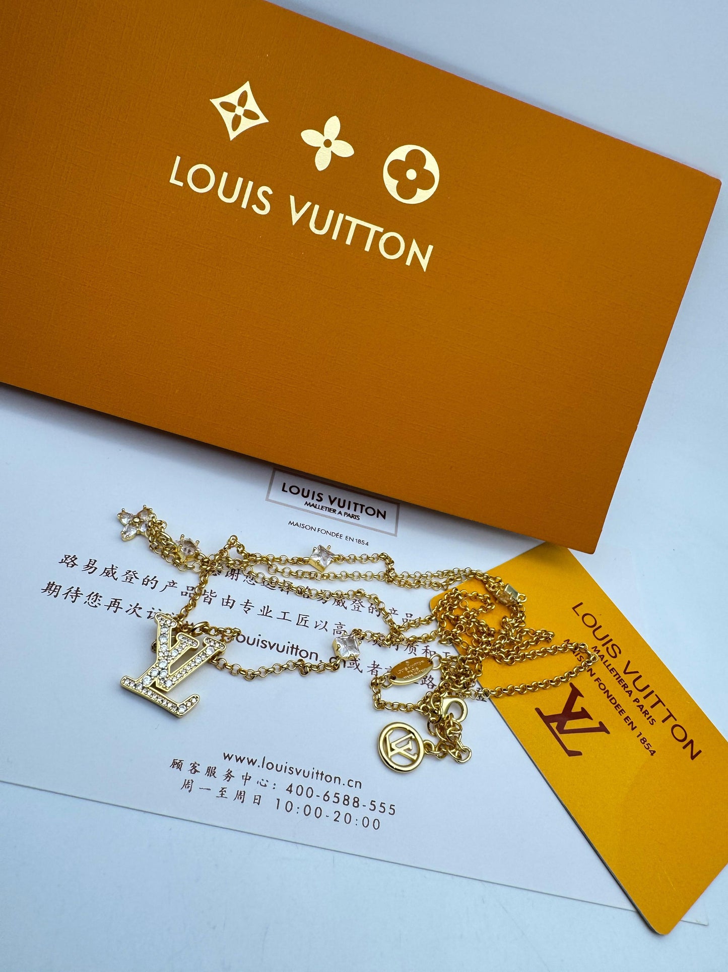 Lou is Vui tton  with packaging and card on a light blue background