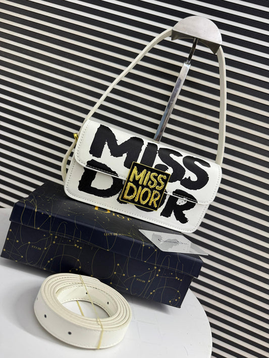 White handbag with 'Mi ss Di or' text on a striped background
