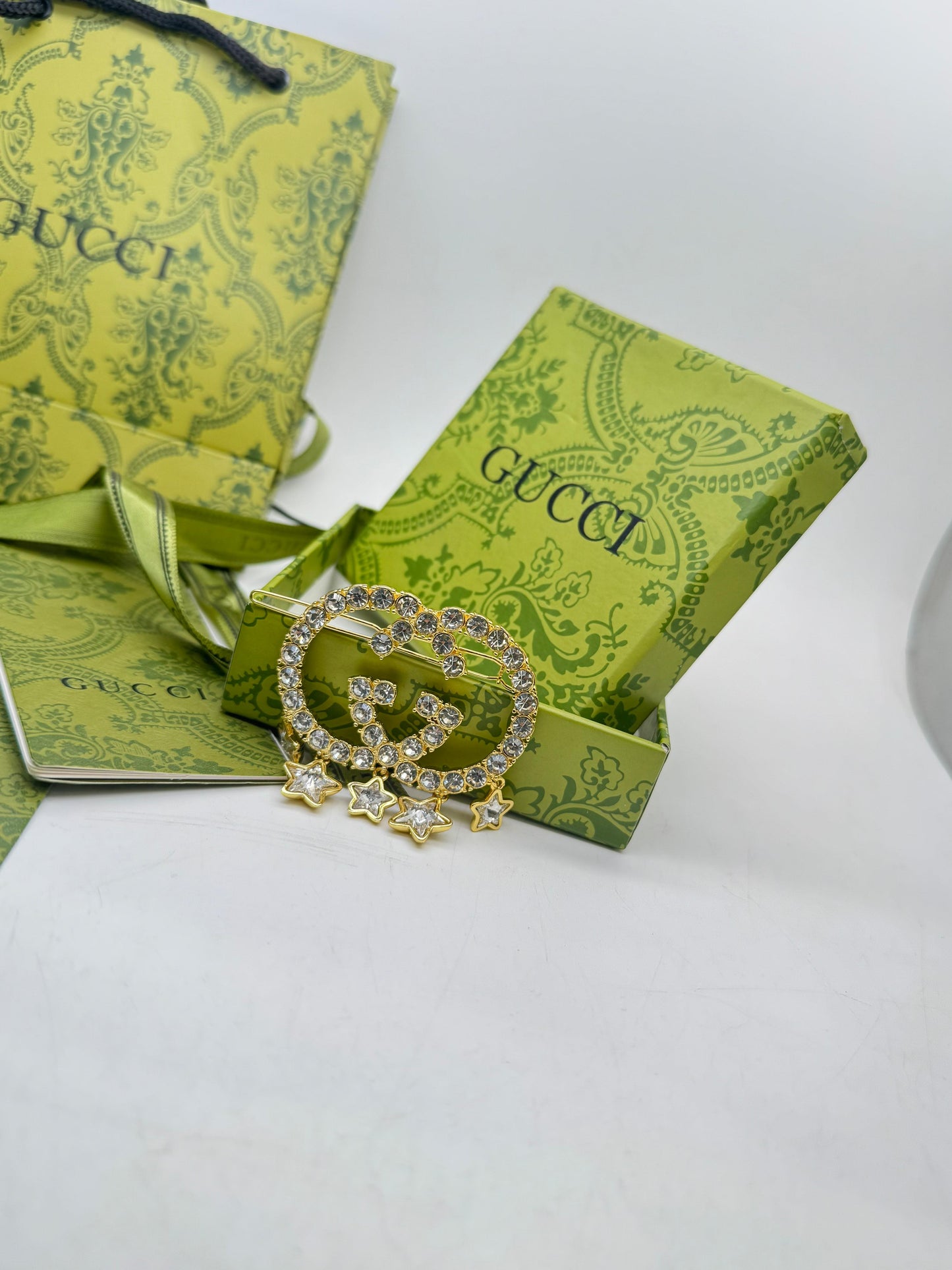 Guc ci jewelry box with a brooch on a white background