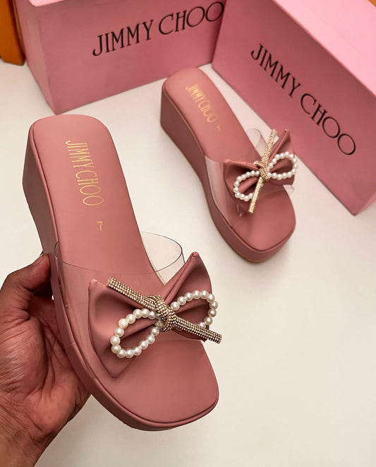 Pink Jim my Ch oo sandals with pearl bows on a white background