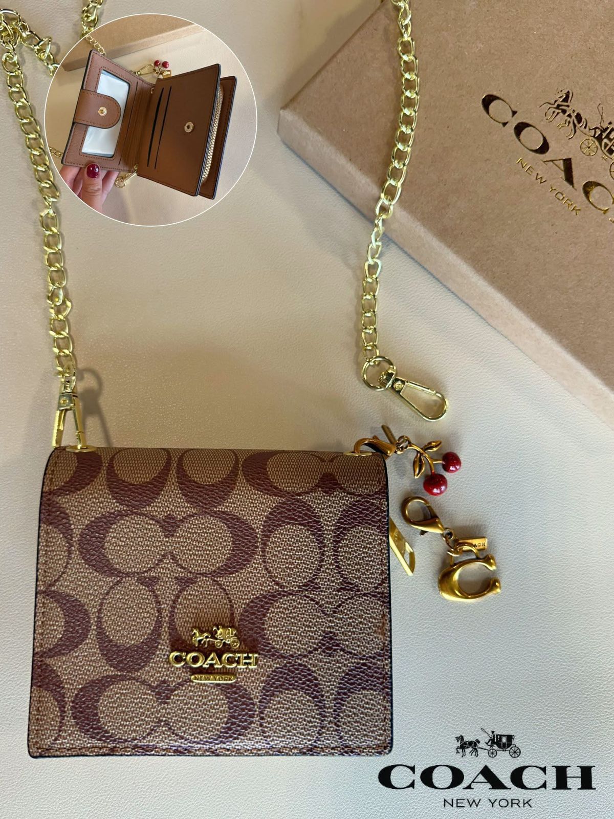 Coa ch handbag with gold chain and keychain on a white surface, with Coach branding visible.