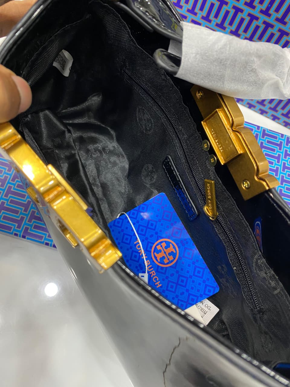 Gold tool with a blue card inside a black case on a patterned surface