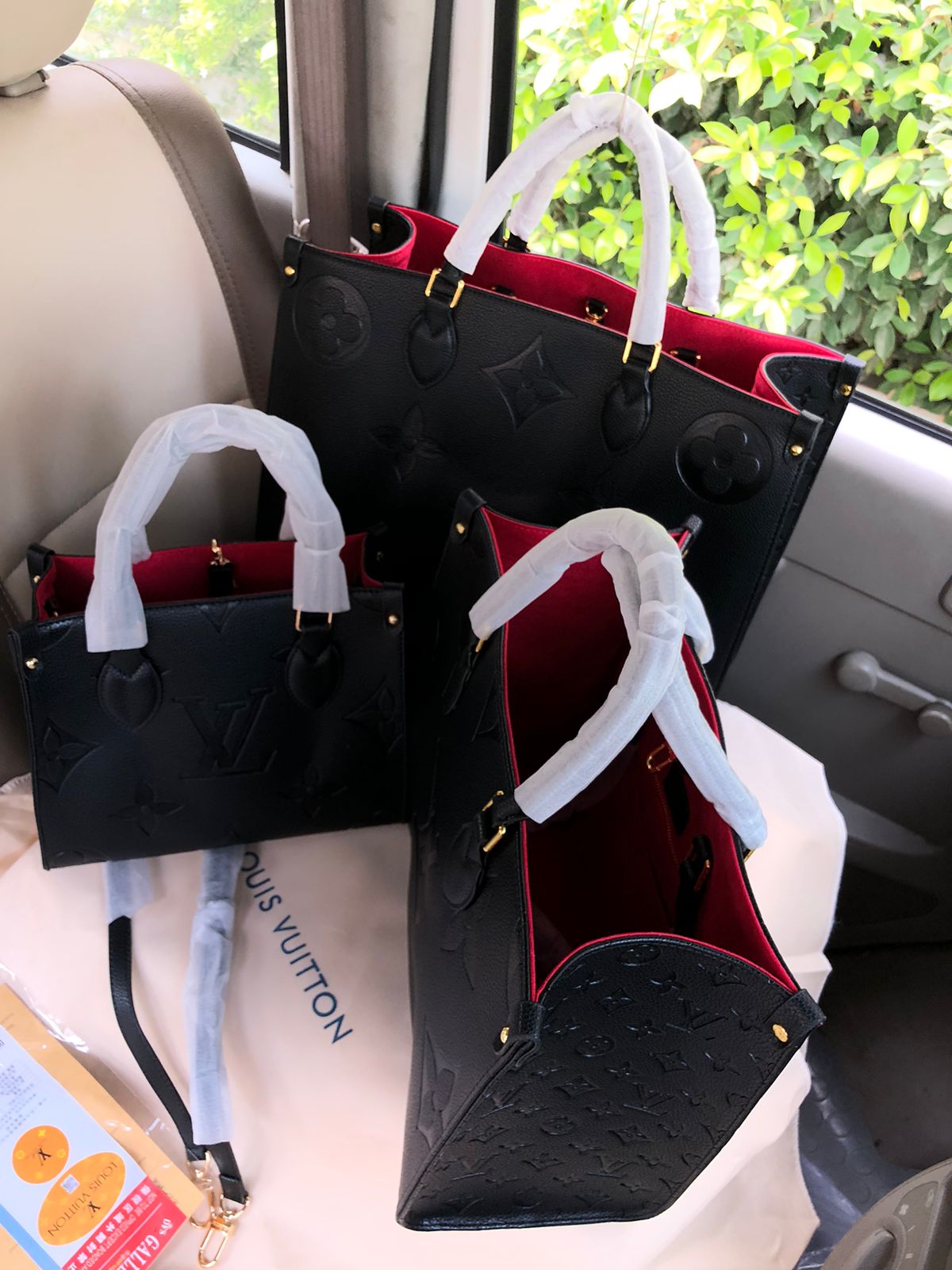 Lou is Vui tton handbags in a car with a visible brand logo.