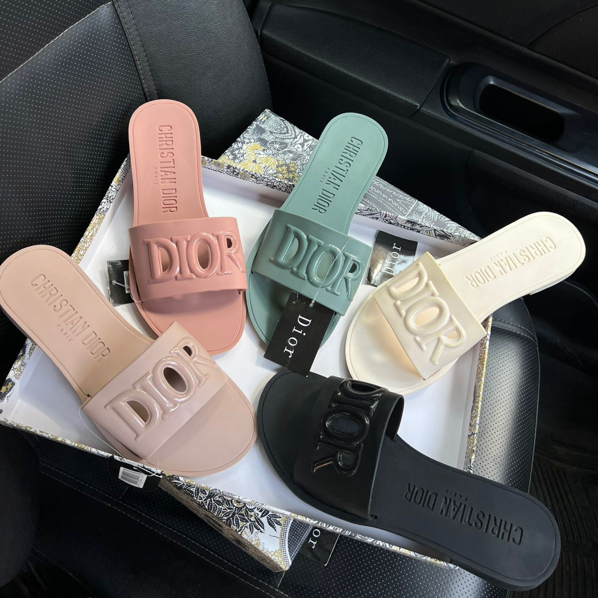 Dior slides in various colors on a car seat