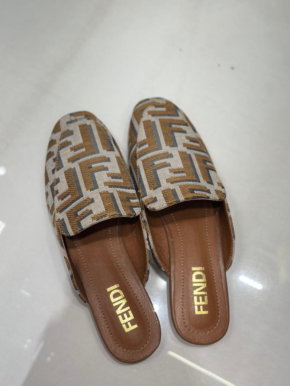 Pair of Fendi slippers on a white background